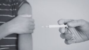 Foto de criança prestes a tomar injeção ilustrando tratamento de transição de gênero