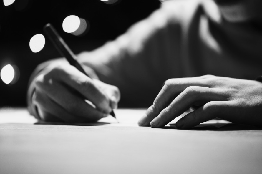 Foto de uma mão feminina escrevendo em ilustração a página sobre artigos de opinião de associadas da MATRIA