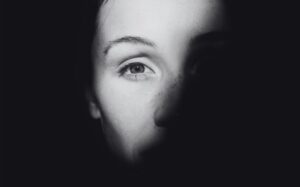 Rosto de mulher nas sombras ilustrando postagem sobre relatório da ONU a respeito de prostituição como violência contra mulheres